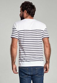 Stribet t-shirt i hvid og marineblå, lavet af bomuld, med korte ærmer og lige kant, vist fra ryggen.