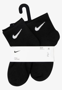 Sorte ankelstrømper i 6-pakning, laget av lettvektstoff, med hvit Nike-logo. Pakket med et pappbånd som viser størrelsesdetaljer.