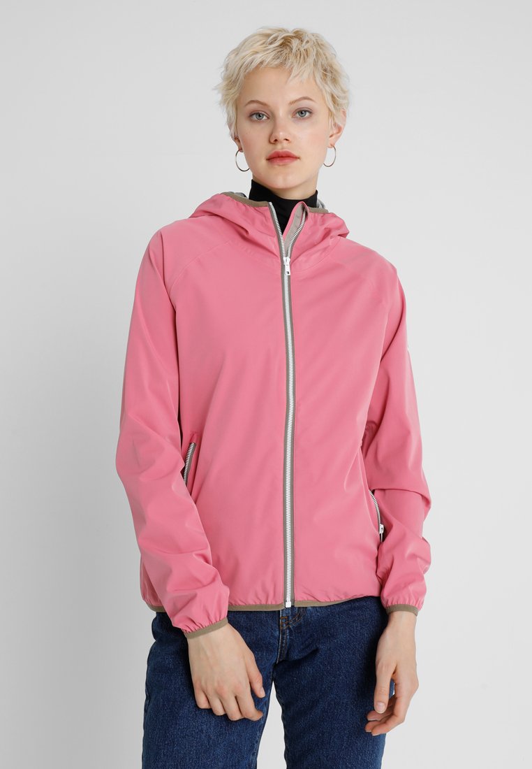 Lichtgewicht roze jack met capuchon, voorkantsluiting en elastische manchetten; gedragen over een zwarte top, gecombineerd met een spijkerbroek.