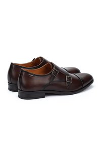 Bruine leren schoenen met een elegant ontwerp, voorzien van een gesps accent en een ronde neus. Soepele textuur met een lage, platte hak.