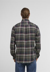 Lange mouwen geruit overhemd in donkergroen, rood en wit. Gemaakt van zacht stof, met een klassieke kraag en manchetten met knopen. Achterventilatiedetail.