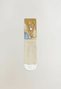 Chaussettes jusqu'aux genoux de couleur jaune moutarde avec un motif tricoté. Présente des personnages animaux ludiques et des rayures blanches et dorées au niveau des bordures.