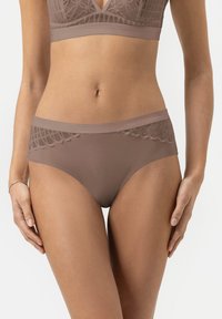 Brown seamless hipster underwear with lace detailing at the waistband, smooth texture, and a moderate rise, positioned on a model's hips.