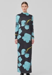 Robe noire à manches longues ornée de grands motifs floraux turquoise et d'accents jaunes, fabriquée en tissu extensible et lisse.