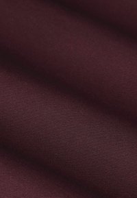 Bordeaux-stof met een soepele textuur en subtiel gestreept patroon. Het materiaal is lichtgewicht en valt zacht.