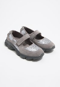 Hallid hallist nahast kingad, mille ees on sädelev hõbedane aktsent ja must kummitald. Omavad Velcro rihma kindlaks sulgemiseks.