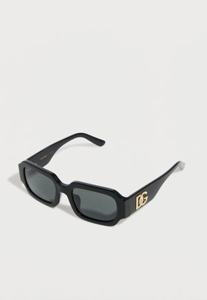 Μαύρα ορθογώνια γυαλιά ηλίου με σκούρους φακούς και χρυσό λογότυπο "DG" στο πλευρό, εκτεθειμένα σε λευκό φόντο.