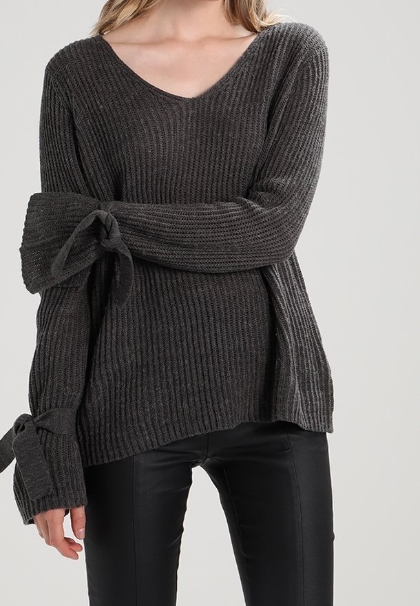 Pull gris foncé côtelé avec col en V et manches longues, avec des accents noués aux poignets. Fabriqué en maille texturée.