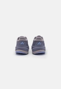 Paarse sportieve schoenen met een gekorrelde mesh bovenwerk, een gevoerde zool en lichtblauwe accenten met het merklogo op beide hielen.