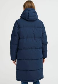 Navy blue puffer coat featuring a hood, long sleeves, and horizontal stitched sections for insulation. Smooth texture with a relaxed fit.