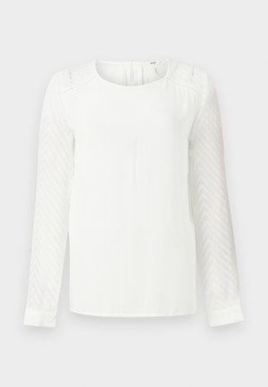 Bluză albă cu mâneci lungi, având un model texturat în zigzag. Materialul corpului este neted, cu un decolteu rotund și închidere cu buton în partea din spate.