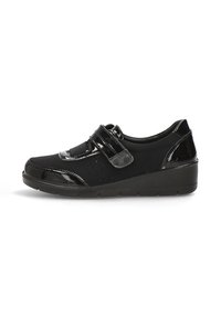 Scarpe nere con tomaia in pelle verniciata, chiusura con strappo in velcro e dettagli testurizzati. Presentano una suola imbottita e un tacco basso a cuneo.