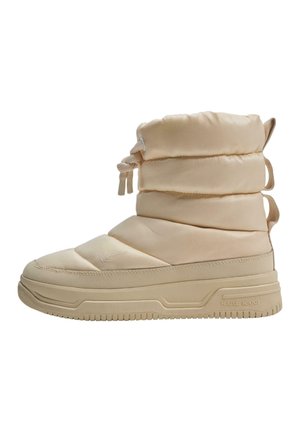 Beige pufferstøvle med et quiltet design, der har rund tå, tekstiloverdel, snørelukning og en tyk gummisål med rillede detaljer.