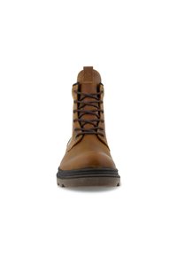 Ruskea nahkainen nilkkabootsi mustilla nauhoilla, pyöreällä varvalla ja kumipohjalla. Varustettu logolla varustetulla kielillä ja vahvistetulla ompelella ylhäällä.