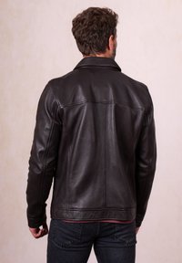 Black leather jacket with a smooth texture, tailored design, and a collared neckline. Features visible stitching and a fitted silhouette.