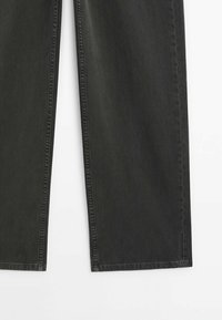 Jean en denim noir à coupe droite avec coutures visibles sur fond blanc.