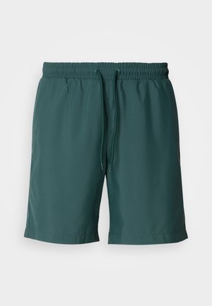 Zeleni, lahki kratki hlače z elastičnim pasom in vrvico, ki imajo gladko teksturo in stranske žepe za lažjo uporabo.