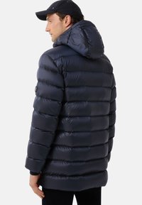 Navy puffer jacket with a hood, featuring a quilted design, shiny texture, and a button detail on the left sleeve.