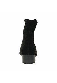 Stivaletti alla caviglia in suede nero con punta rotonda, altezze corte e tacco largo. Presentano un dettaglio cucito e una cerniera laterale per la chiusura.
