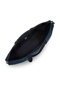 Sac bleu marine avec un extérieur lisse, fermeture zippée et doublure en tissu noir. Présente un accent en pompon et des poignées de transport doubles. Large ouverture.