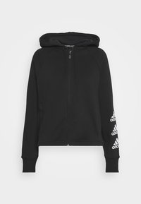 Felpa nera con zip, cappuccio, polsini e orlo a coste. Presenta dettagli del logo bianco Adidas sulla manica sinistra. Realizzata in tessuto morbido.