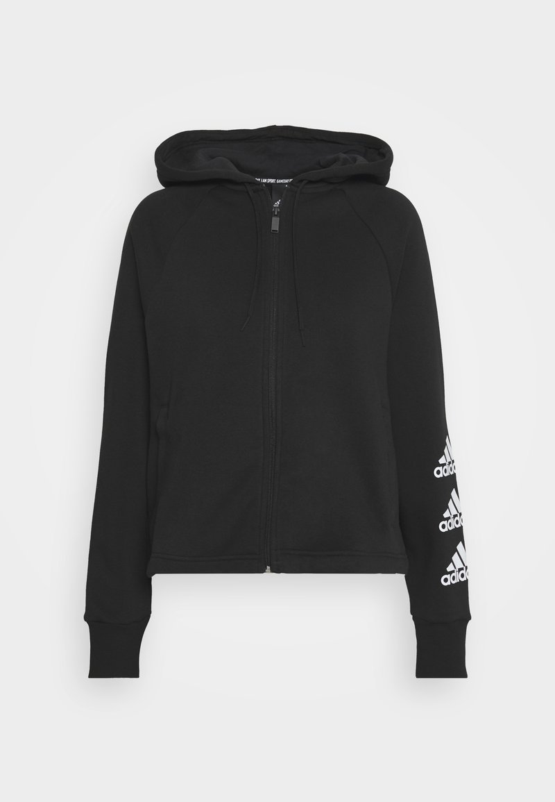 Felpa nera con zip, cappuccio, polsini e orlo a coste. Presenta dettagli del logo bianco Adidas sulla manica sinistra. Realizzata in tessuto morbido.
