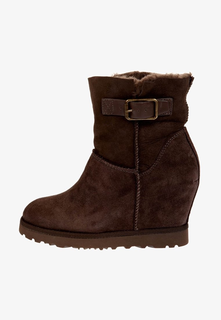 Brązowe zamszowe botki na wedges z podszewką z sztucznego futra, dekoracyjnym detalem w postaci klamry oraz teksturowaną gumową podeszwą, z zaokrąglonym noskiem i zakrzywioną formą.