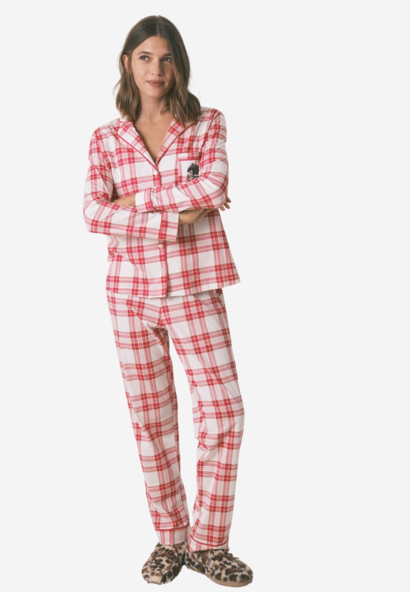 Set di pigiama a quadri rossi e bianchi con maniche lunghe, maglietta con bottoni e pantaloni coordinati. Presenta una tasca sul petto; abbinato a pantofole con stampa leopardata.