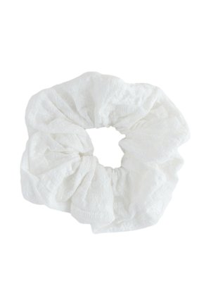 Weißes Stoff-Scrunchie mit subtil strukturiertem Muster, abgebildet vor einem schlichten weißen Hintergrund.