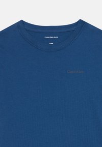 Herre blå bomull T-skjorte med rund hals, korte ermer og en subtil Calvin Klein-logo i en lysere nyanse foran.