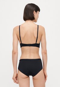 Black bikini set featuring a simple design. The top has adjustable straps and a clasp back, while the bottom has a high-waisted cut.