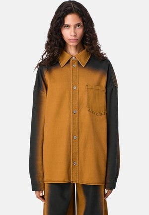 Oversized koszula dżinsowa w brązowo-czarny gradient, z kołnierzykiem w kształcie punktu, metalowymi zatrzaskami i jedną kieszenią na piersi. Gładka tekstura, luźny krój.