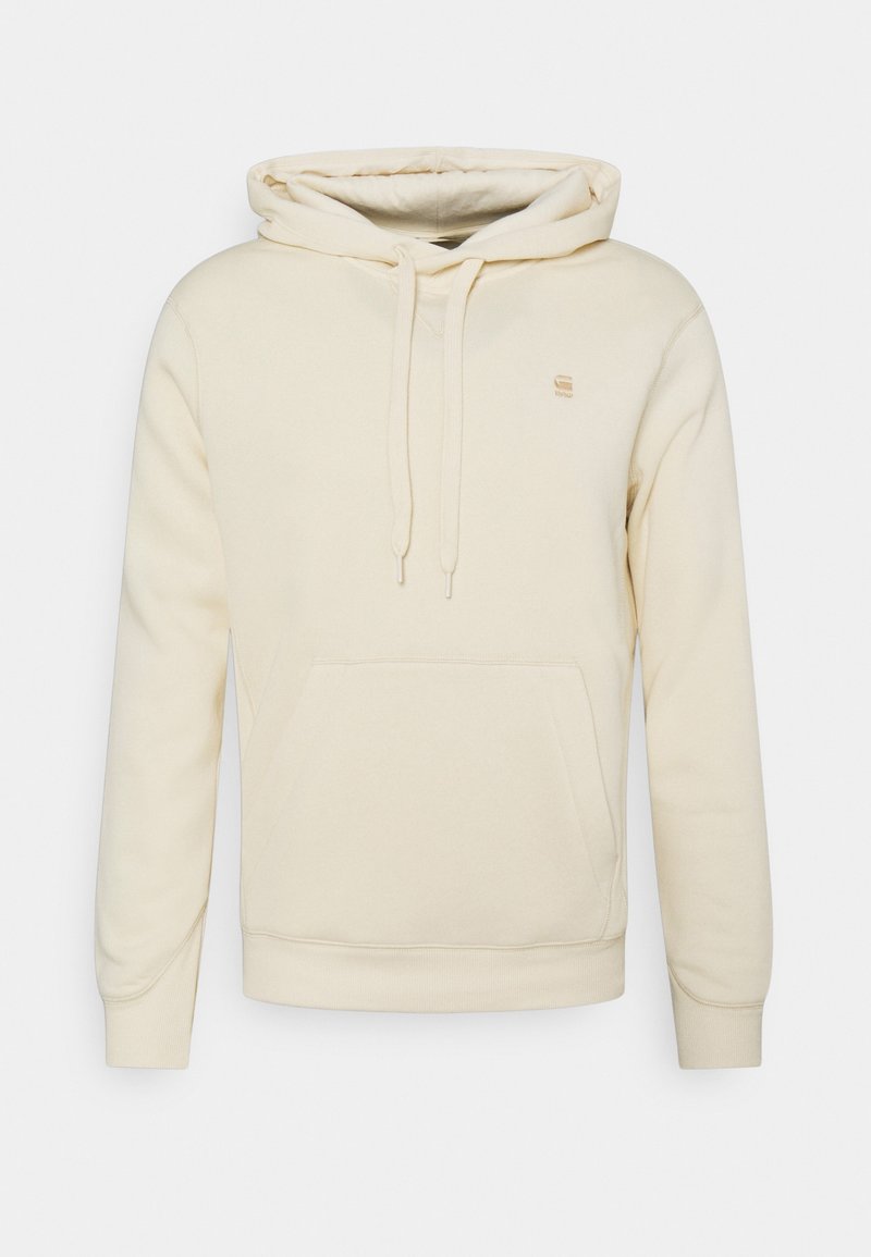 Béžová mikina s kapucí vyrobená z měkké látky. Má kapuci na stažení šňůrkou, kapsu typu klokanka a žebrované manžety. Výšivka loga na hrudi.