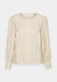 Blusa color crema con scollatura rotonda, maniche a sbuffo e pieghe verticali. Tessuto morbido e testurizzato con chiusura a bottone sul retro.