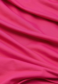 Ljust rosa syntetiskt tyg med en slät textur, som har mjuka veck och en lätt lyster, och framhäver sin lätta och flexibla design.