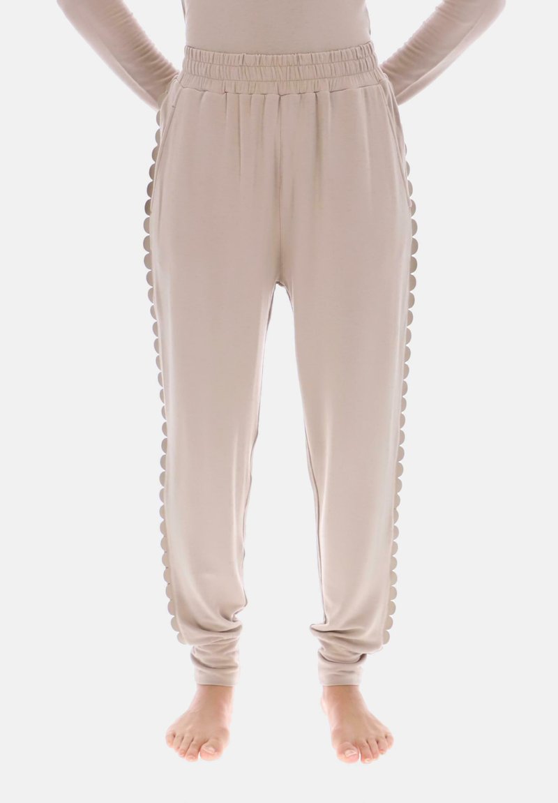 Beige joggebukser med bølget sidentrim, elastisk linning og taperet ben design. Fremstillet af blødt, letvægtsstof.