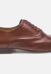Braune Lederschuhe mit glatter Textur, runder Zehenform und einer Schnürung mit fünf Ösen. Merkmale sind eine dezente, geschwungene Nahtdetail und ein Holzabsatz.