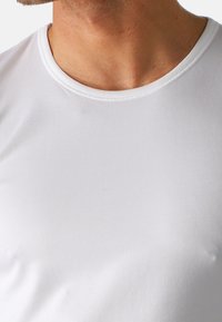 Weißes T-Shirt mit kurzen Ärmeln aus weichem, glattem Stoff. Mit Rundhalsausschnitt und nahtloser Verarbeitung für hohen Tragekomfort.