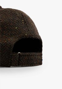 Gorra de espiga marrón hecha de lana texturizada, con una correa ajustable con herrajes metálicos en la parte posterior.