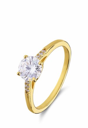 Geelgouden ring met een grote ronde heldere edelsteen in het midden en kleinere heldere stenen aan weerszijden in de band.