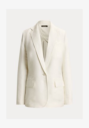 Κρεμ σακάκι ραμμένο στα μέτρα, με γιακά με σχισμή, κλείσιμο με ένα κουμπί, δύο τσέπες με καπάκι και εσωτερική ετικέτα με το λογότυπο.