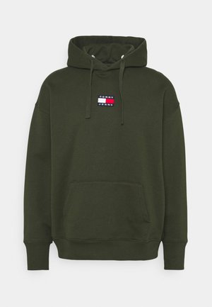 Ciemnozielona bluza z kapturem, z przednią kieszenią kangurzą i małą naszywką z logo Tommy Jeans umieszczoną na środku klatki piersiowej.