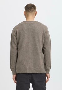 Knitted sweater in light brown with long sleeves and a crew neckline. Features a textured finish and ribbed cuffs and hem.