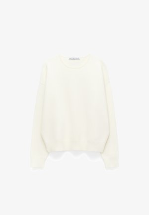 Biała dzianinowa bluza z okrągłym dekoltem, opuszczonymi ramionami oraz ściągaczami u dołu i na mankietach. Materiał o fakturze, luźny krój, prosty design.