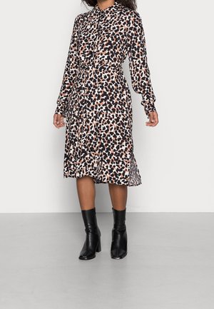Robe imprimée léopard avec un col, des manches longues et une taille cintrée. Le tissu est léger, évasé à l'ourlet, associé à des bottines noires.