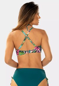 Kwiatowy stanik bikini z wielokolorowym wzorem, z regulowanymi ramiączkami skrzyżowanymi na plecach, połączony z turkusowymi majtkami kąpielowymi.