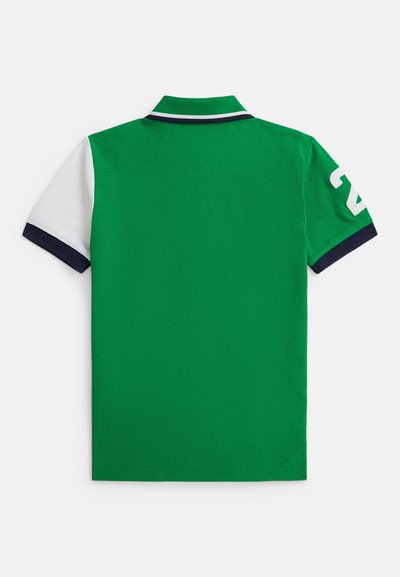 Πράσινο πόλο μπλουζάκι με υφή. Διαθέτει κοντό μανίκι σε λευκό χρώμα που αντιπαραβάλλεται και γιακά σε ναυτικό μπλε, με τον αριθμό «24» στο μανίκι.