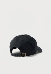 Μαύρο βαμβακερό καπέλο του μπέιζμπολ με ρυθμιζόμενο λουράκι και ορειχάλκινο αγκράφα, εμφανιζόμενο από πίσω σε λευκό φόντο.