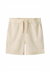 Shorts beiges en tissu doux et texturé. Dotés d'une taille élastique avec cordon de serrage, de deux poches latérales et de revers roulés.