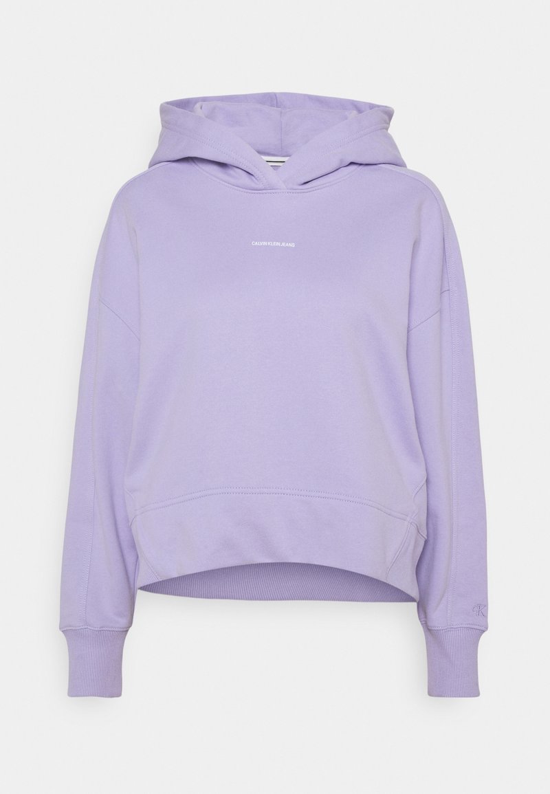 Lila kort hoodie med känguruficka, ribbade muddarna och "Calvin Klein Jeans"-logotyp i liten vit text på bröstet.